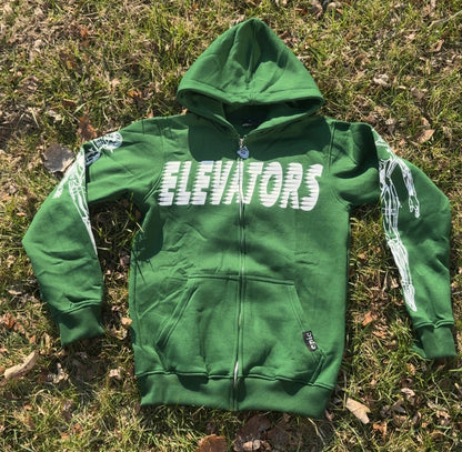 Elevators Hoodie displayed on grass, featuring a vibrant green color and unique graphic design for a motivational lifestyle.